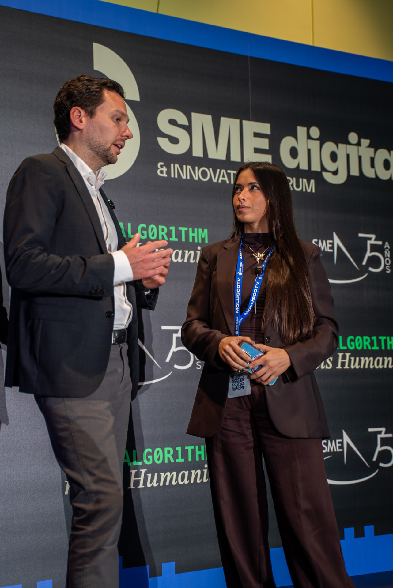 Two speakers talking together on an event stage
