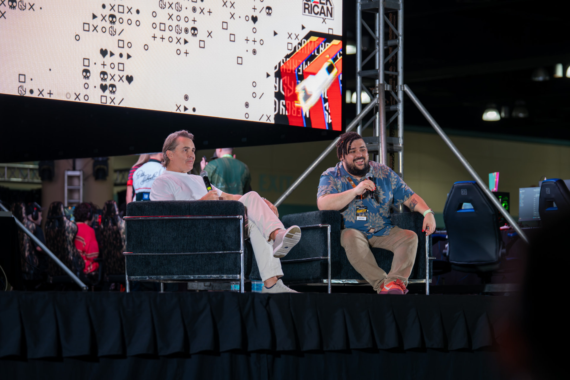 Two guests sharing a light moment during a convention panel
