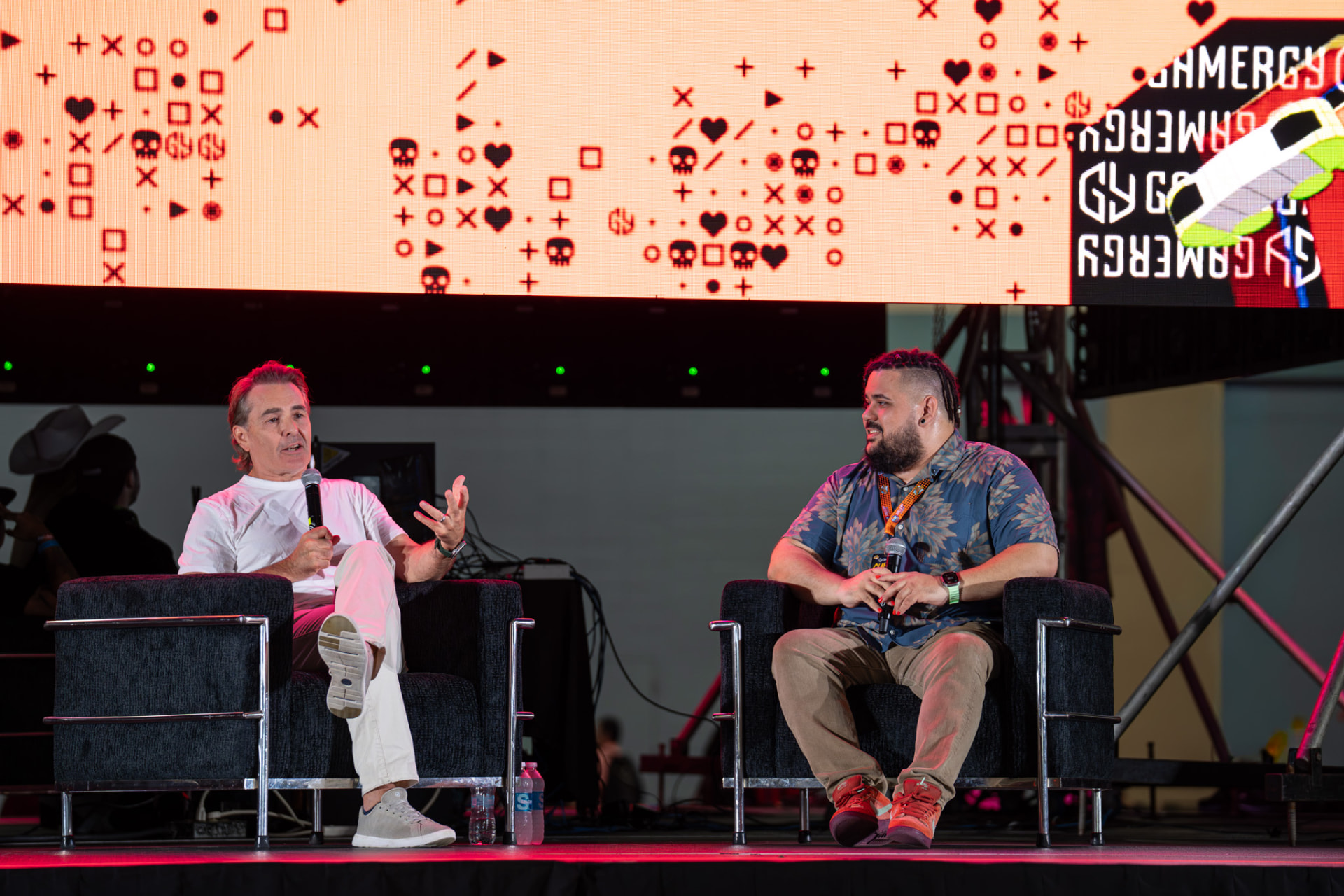 Two panelists in conversation on the convention stage