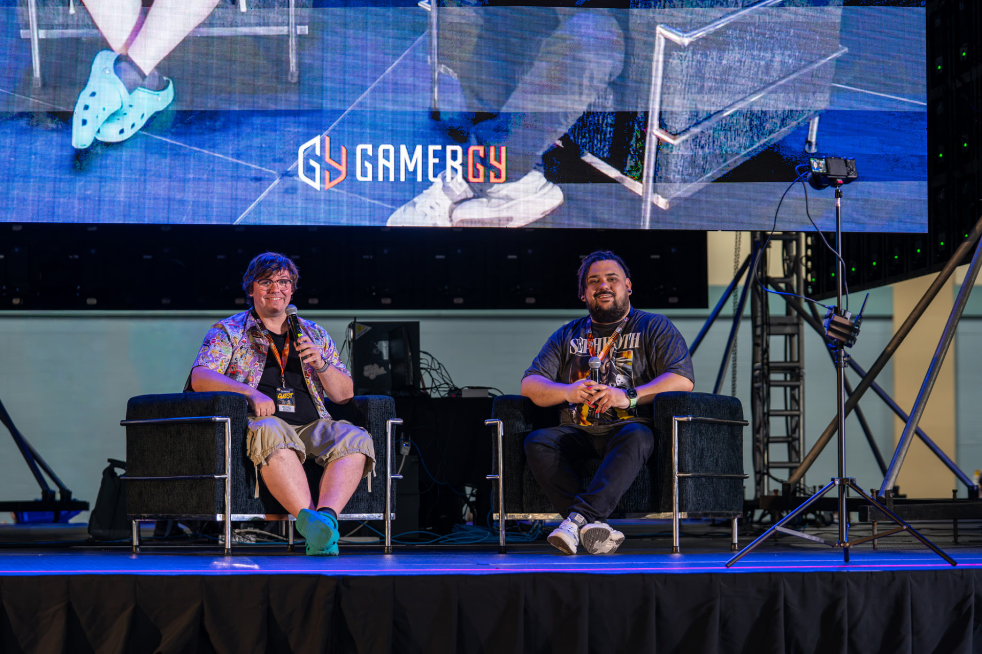 Two gaming personalities speaking together on a convention stage