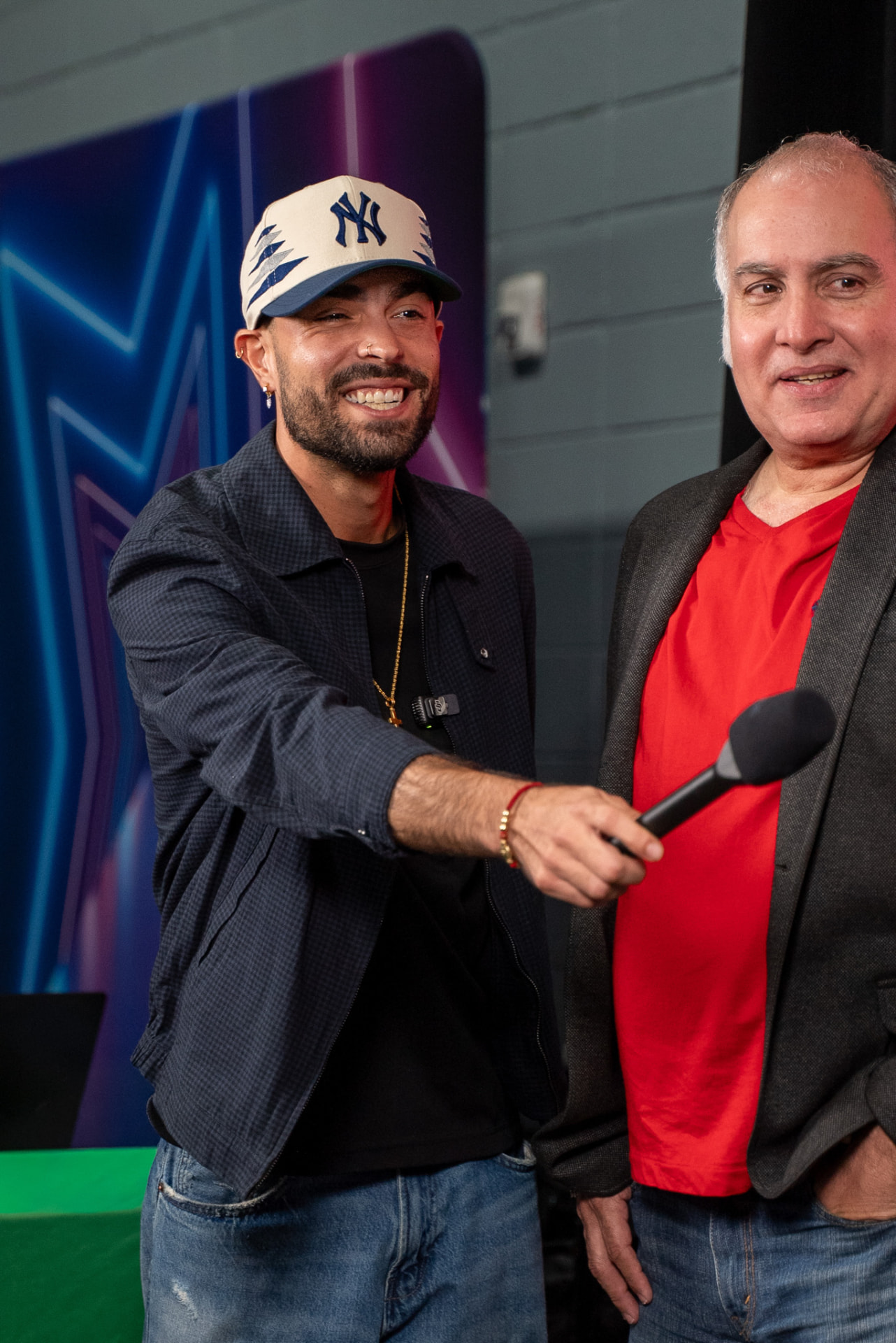 Interviewer holding a microphone beside an event guest