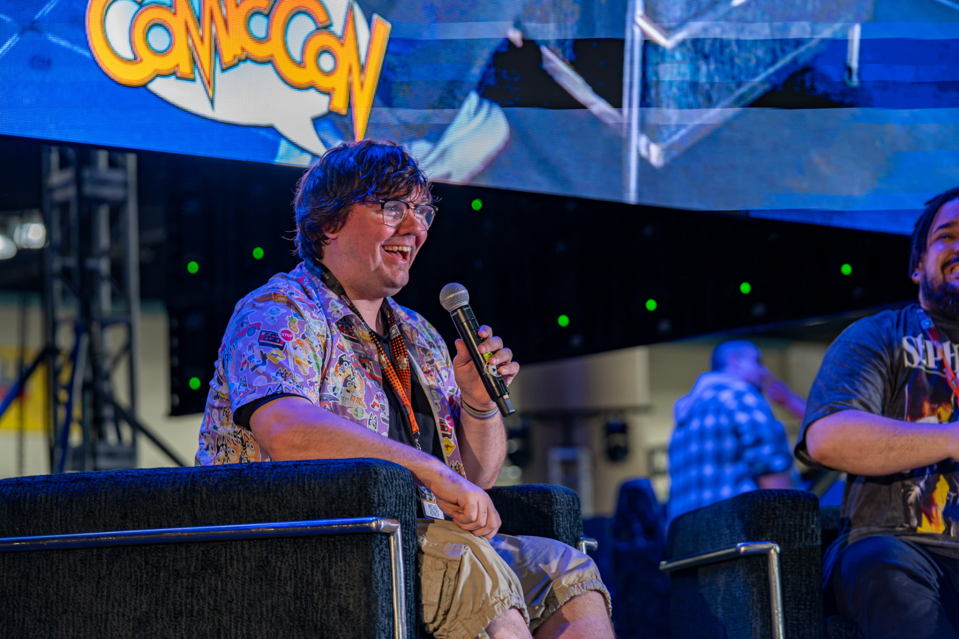 Convention guest smiling while speaking into a microphone