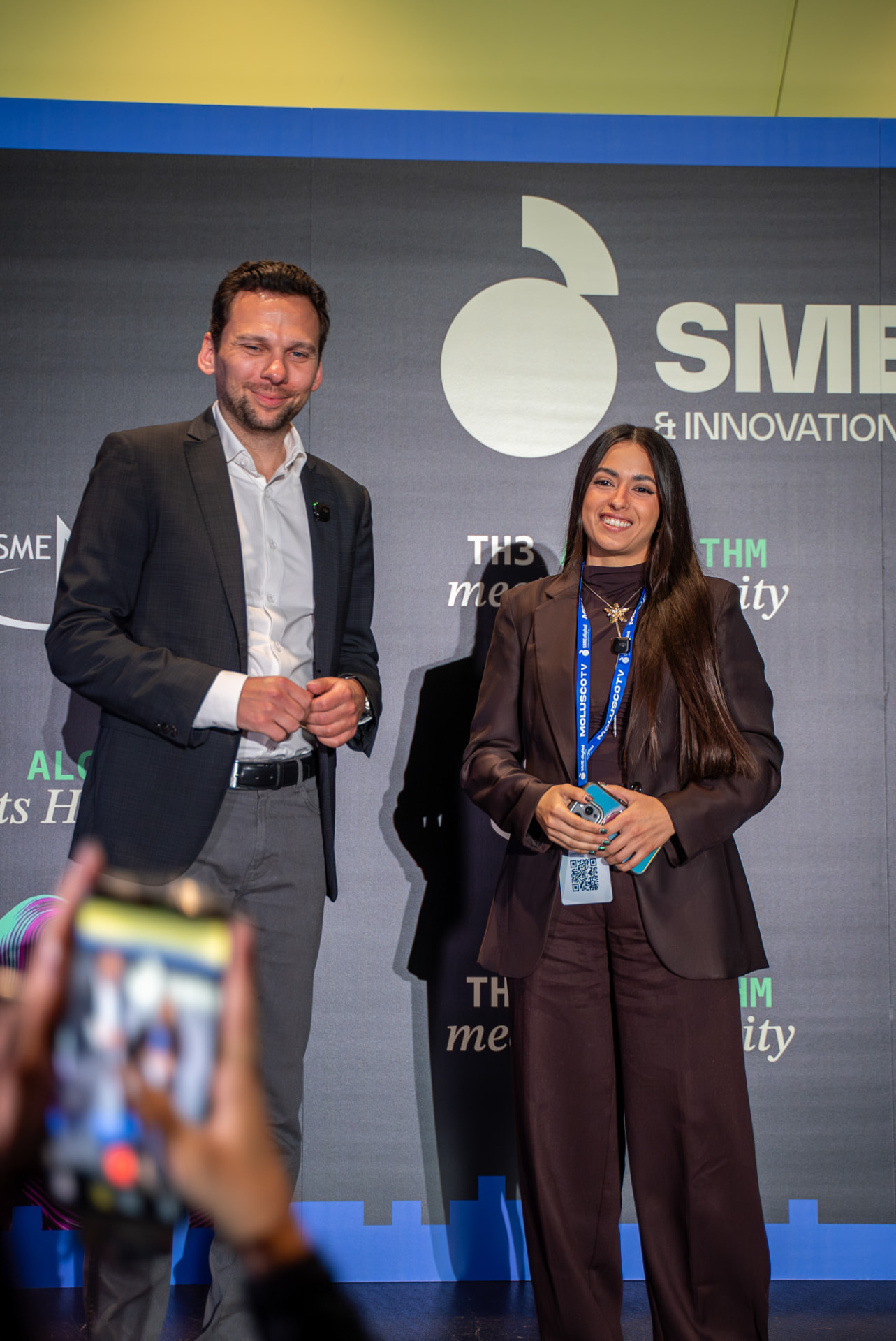 Two event speakers posing together on stage