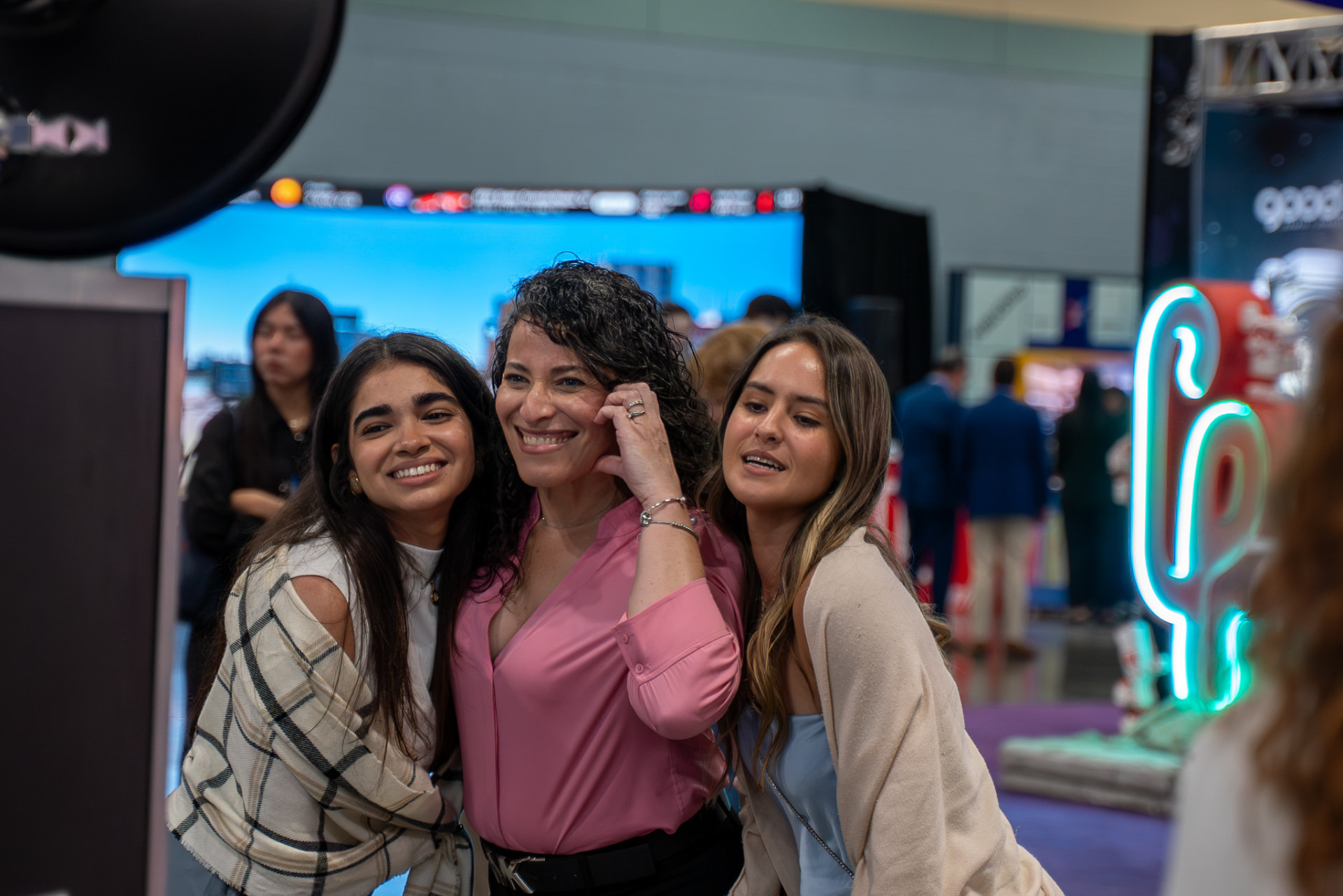 Three attendees posing together on an expo floor